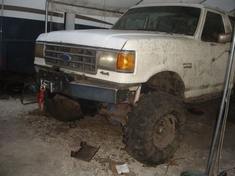 1989 Ford Bronco - Mud-covered 1989 Ford Bronco with a winch mounted to the front bumper.