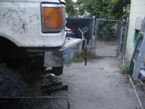 1989 Ford Bronco - Rear view of a white 1989 Ford Bronco, showing its chrome bumper and a large off-road tire.