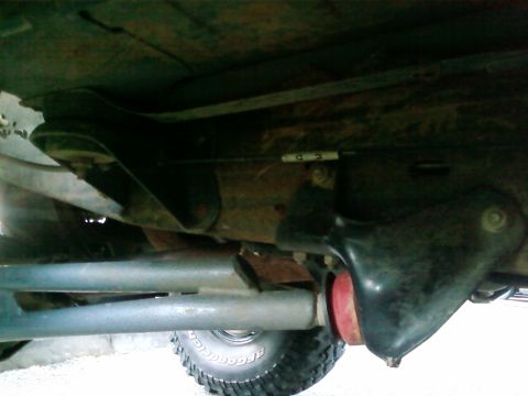 1995 Ford Bronco - Close-up of vehicle undercarriage, focusing on suspension and tire details.