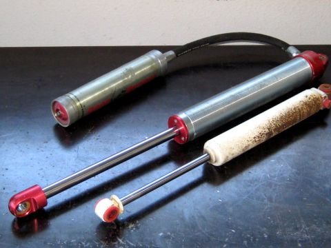 1996 Ford Bronco - Three shock absorbers are shown, with one appearing heavily corroded and dirty.