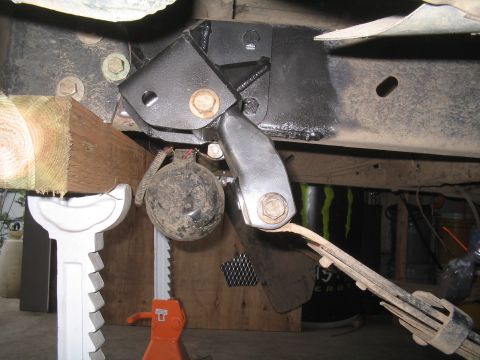 1979 Ford Bronco - Close-up view of modified vehicle suspension components, including a leaf spring and custom bracketry.