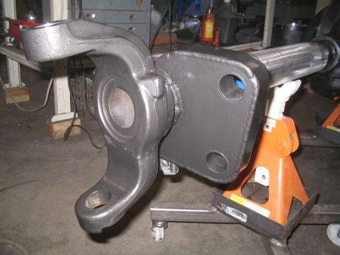 1979 Ford Bronco - Custom suspension part, likely for an off-road vehicle, is supported by jack stands in a garage setting.