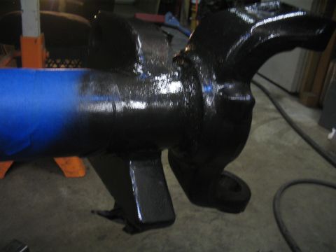 1979 Ford Bronco - A vehicle axle is shown after being painted black, with blue tape marking a section.