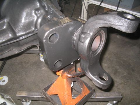1979 Ford Bronco - Close-up of a vehicle's differential housing and a suspension component, supported by an orange jack stand.