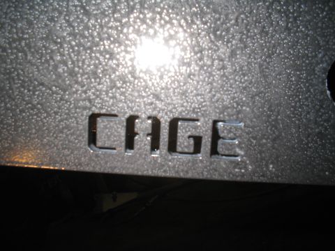 1979 Ford Bronco - Close-up of a metal panel with the word CAGE cut out, likely part of a custom build.