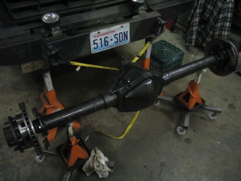 1979 Ford Bronco - A vehicle's rear axle assembly is supported by jack stands in a garage setting.