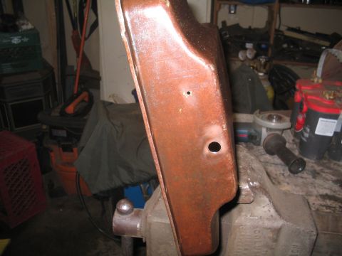 1979 Ford Bronco - A rusty metal component is secured in a vise, ready for work in a cluttered garage setting.