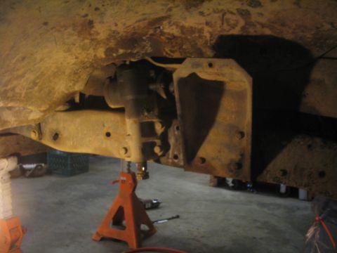 1979 Ford Bronco - Undercarriage view of a vehicle undergoing modification or repair, supported by jack stands.