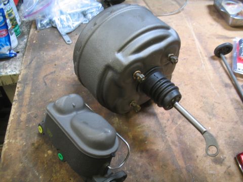 1979 Ford Bronco - A brake booster and master cylinder are shown on a workbench, likely for a vehicle repair or upgrade.