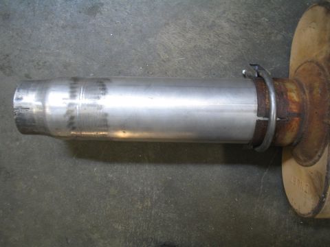 1979 Ford Bronco - A close-up view of a vehicle's exhaust system, showing a pipe and muffler assembly.