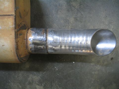 1979 Ford Bronco - A close-up view of a modified exhaust pipe, showing a welded section and a clean cut at the end.
