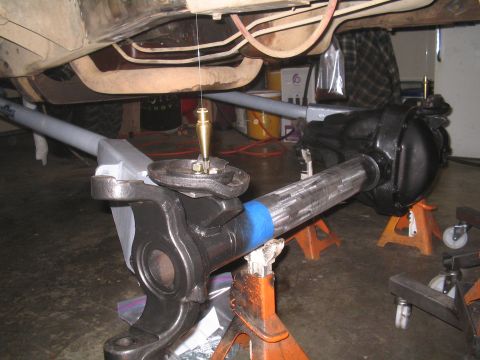 1979 Ford Bronco - Front axle assembly being worked on, with a plumb bob used for alignment.