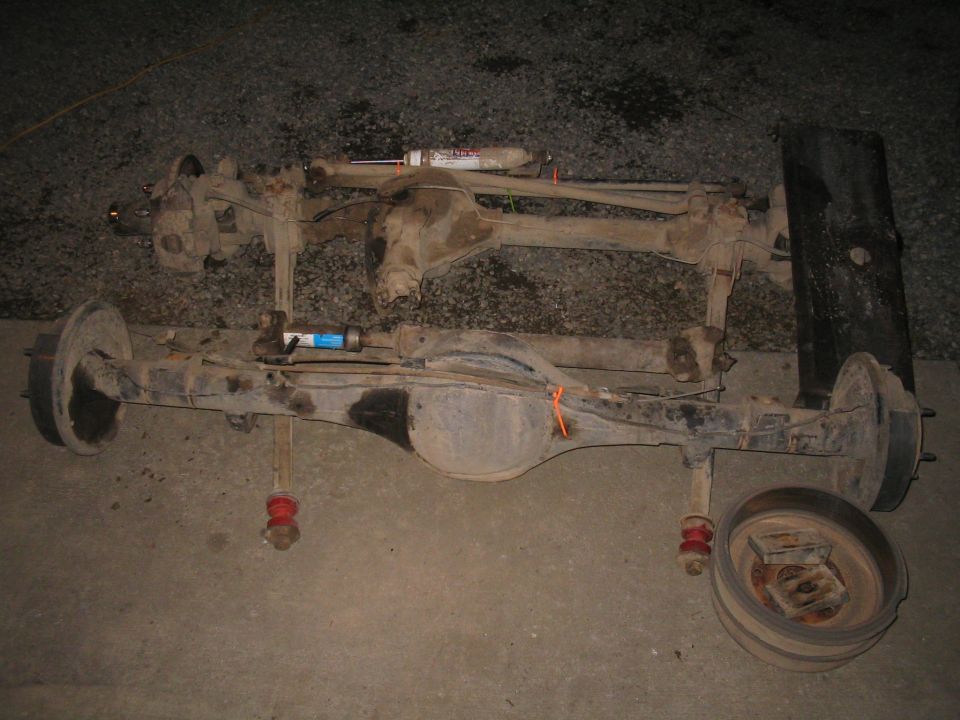 two vehicle axles with shocks and brake drums
