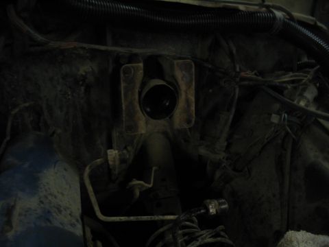 1979 Ford Bronco - Close-up view of engine bay components, including hoses and wiring, with a central metal bracket.