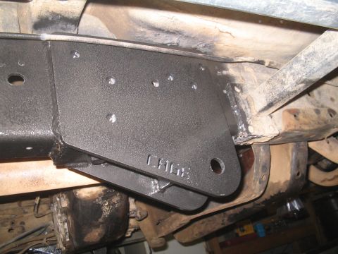 1979 Ford Bronco - Close-up view of a custom "CAGE" bracket installed on a vehicle's undercarriage.