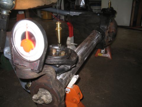 1979 Ford Bronco - Close-up of automotive axle assembly with measurement tools being used for alignment.