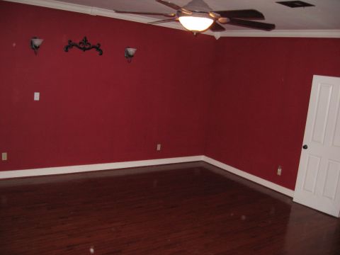 2006 Ford F-150 - An interior view of a room red walls, a dark wood floor, a ceiling fan, and a white door on the right side.