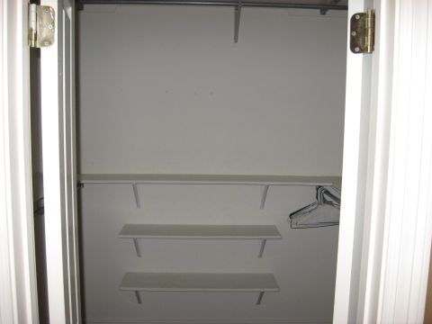 2006 Ford F-150 - The interior of a white closet with shelving and a hanging rod is shown.