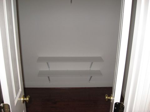 2006 Ford F-150 - Interior view of an empty closet two white shelves mounted on the wall above a dark wood floor.