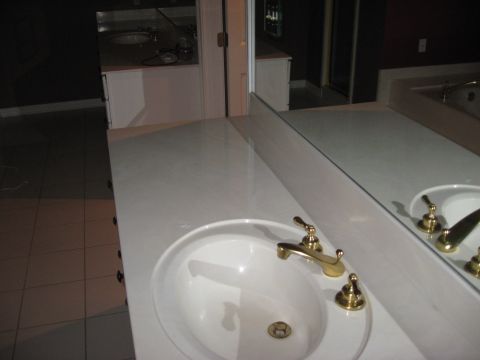 2006 Ford F-150 - A bathroom vanity area a sink, faucet, and a large mirror that shows a reflection of another vanity.
