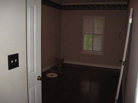 2006 Ford F-150 - A view into an empty room with hardwood floors and a window covered by white shutters.