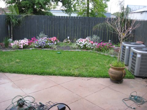 2006 Ford F-150 - Backyard view a flower bed, lawn, and outdoor AC units.