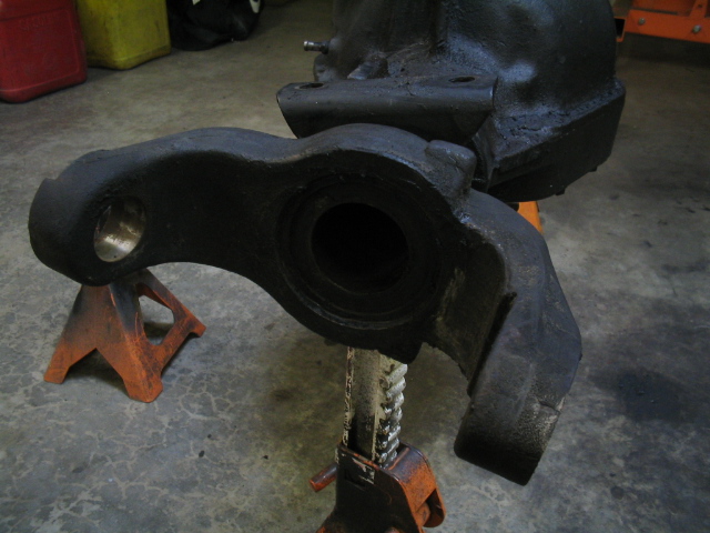 Black metal vehicle suspension component on orange jack stands