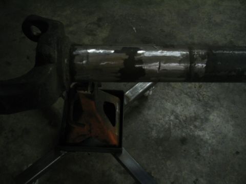 1979 Ford Bronco - Close-up of a vehicle's axle housing, supported by a jack stand, with visible weld repairs.