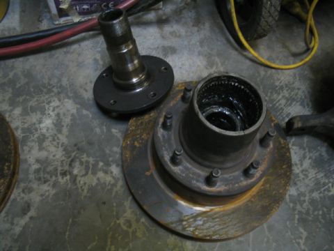 1979 Ford Bronco - Wheel hub and brake rotor components are shown on a concrete floor.