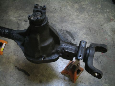 1979 Ford Bronco - Close-up view of a differential housing and driveshaft yoke, resting on a jack stand.