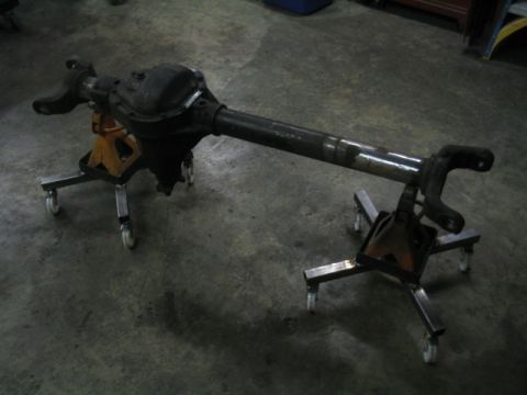 1979 Ford Bronco - A vehicle's rear axle assembly is shown supported by jack stands on a concrete floor.