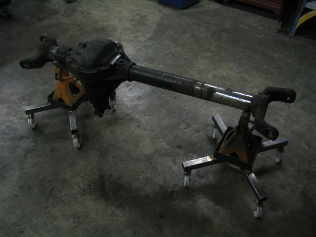 vehicle rear axle assembly on jack stands with wheels