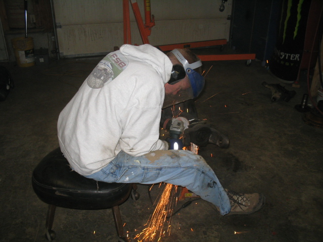 Person grinding metal in a garage