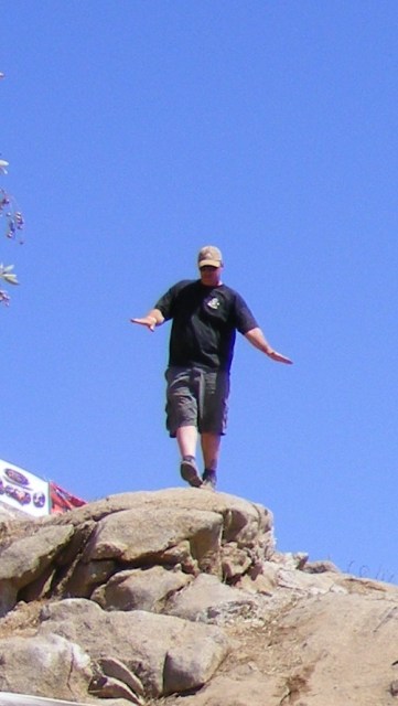 1992 Toyota Tacoma - A person stands on a rocky outcrop under a clear blue sky.