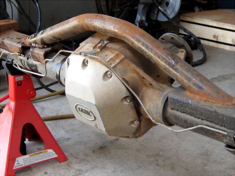 1996 Ford Bronco - Ford Bronco rear axle assembly with a "KIRK" differential cover, supported by jack stands.