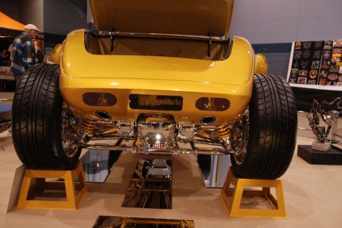 1996 Ford Bronco - Custom yellow hot rod displayed with its trunk open and wide tires on display stands.