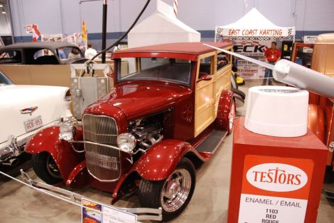 1996 Ford Bronco - A custom red and wood-paneled hot rod is displayed indoors, with a large can of red paint in the foreground.