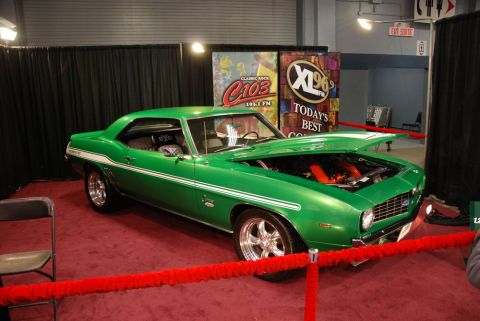 1996 Ford Bronco - A green 1969 Chevrolet Camaro is displayed indoors with its hood open, revealing the engine.