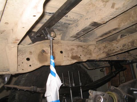 1979 Ford Bronco - Close-up view of the undercarriage, focusing on suspension and frame modifications with some unidentified hanging object.