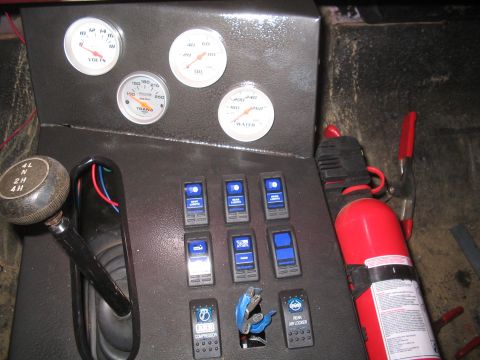 1979 Ford Bronco - Overhead close-up of a custom bedlined center console with four white-faced Auto Meter gauges (volts, oil pressure, trans temp, water temp)…