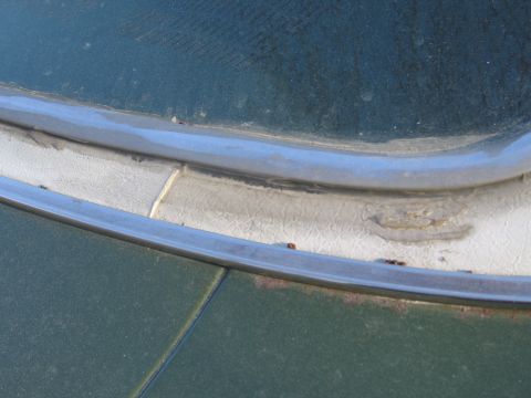 1991 Ford LTD Crown Victoria - Close-up view of the windshield trim and cowl area on a green vehicle.