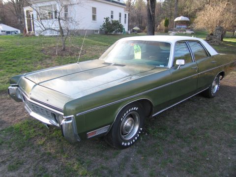 1991 Ford LTD Crown Victoria - This sedan, likely from the early 1970s, is parked outside a house with a white roof.