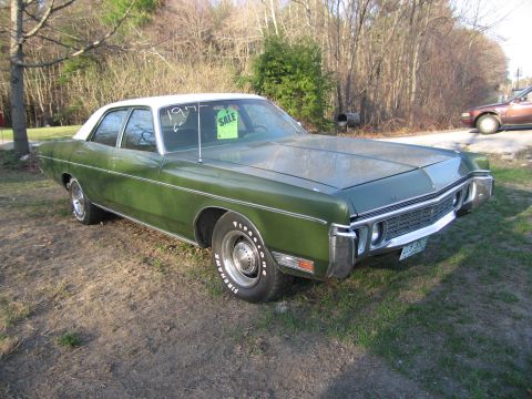 1991 Ford LTD Crown Victoria - Green sedan with white roof, likely a 1977 model, parked on a grassy area with trees in the background.