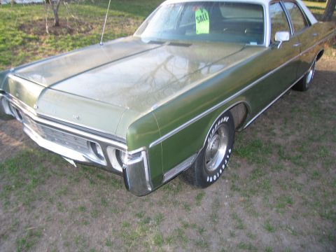 1991 Ford LTD Crown Victoria - A green sedan with a white roof sits parked outdoors on a grassy area, displaying a 'SALE' sign.