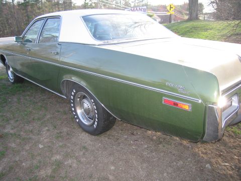 1991 Ford LTD Crown Victoria - This green and white sedan is seen from the rear quarter angle.