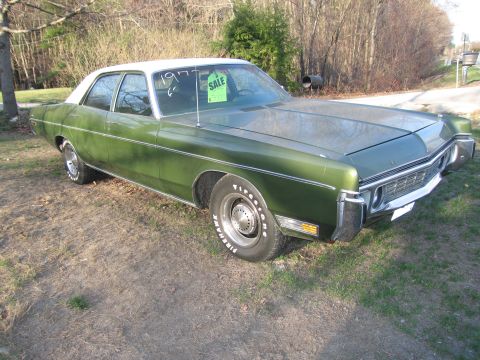 1991 Ford LTD Crown Victoria - This green sedan with a white roof has '1977' written on the windshield, indicating its model year.