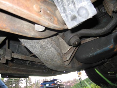 1991 Ford LTD Crown Victoria - Underside view of a vehicle's suspension system, showing various metal parts and rubber bushings.