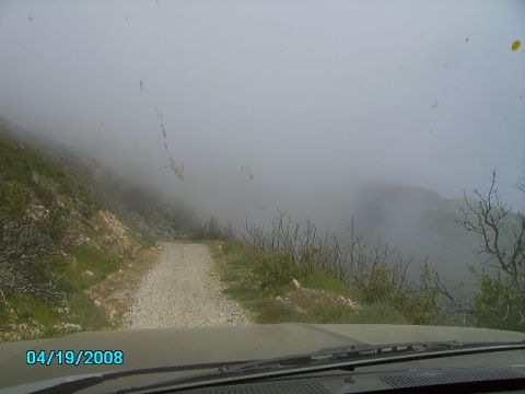 1990 Ford Bronco - Driving on a foggy gravel road with limited visibility.