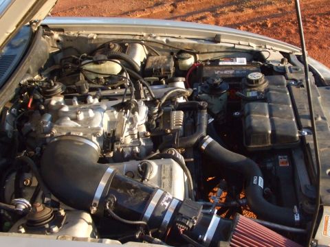 1999 Ford Mustang - Close-up view of a car's engine bay, showing various components and aftermarket modifications.