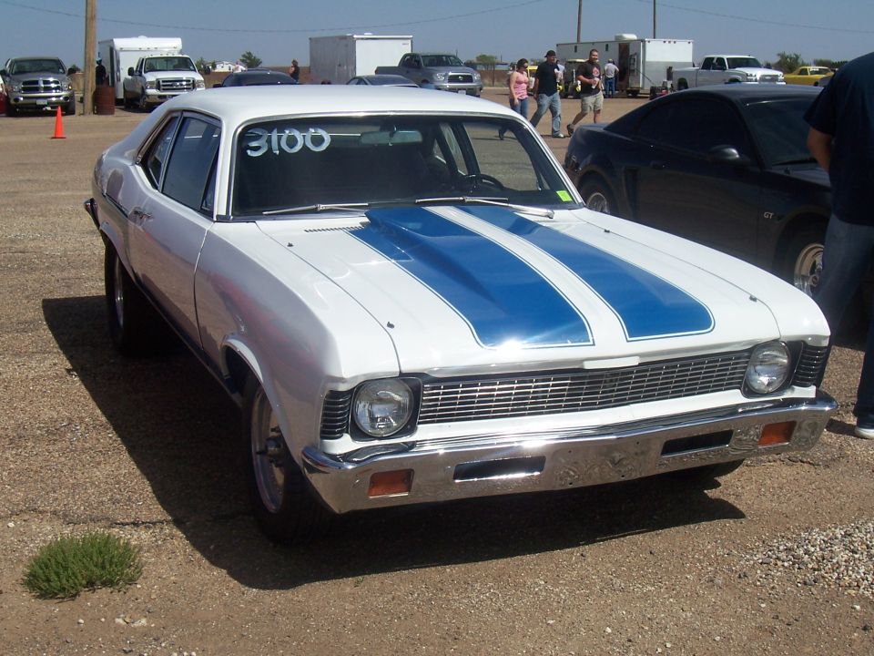 White sedan with blue racing stripes and a chrome bumper, showing race number 3100 on the windshield